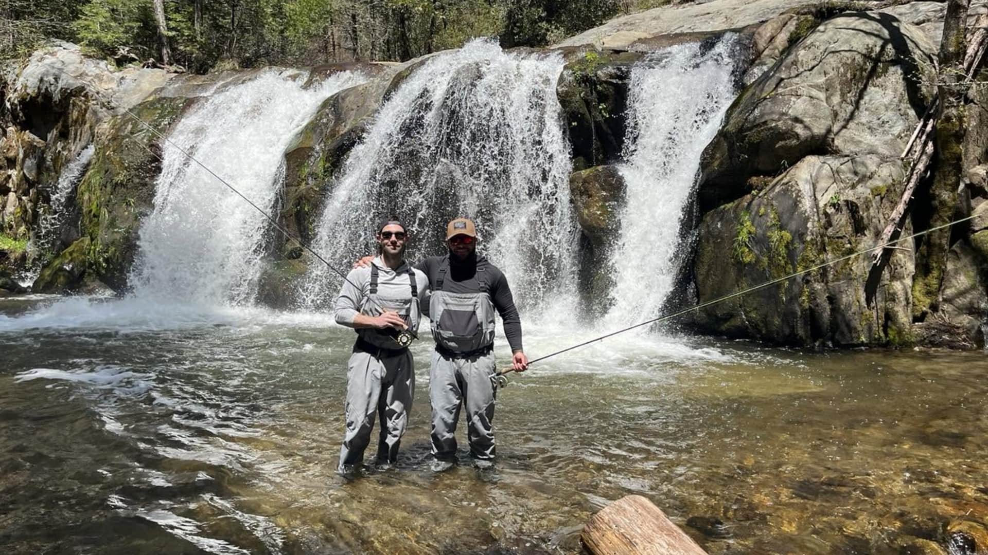Two anglers on a guided fly fishing trip in front of a High Sierra waterfall